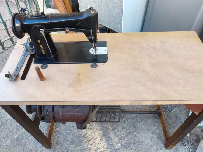 Máquina de costura industrial antiga com motor e móvel