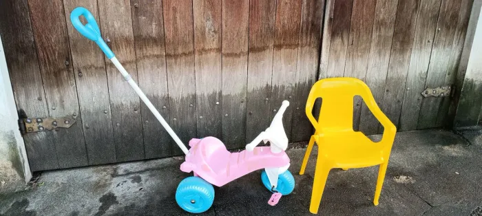 Conjunto Velocípede Bandeirantes Rosa com empurrador e cadeirinha infantil amarela.