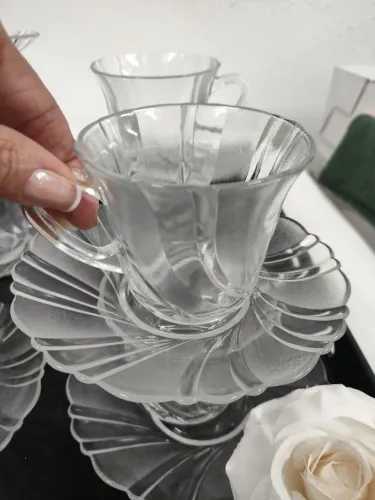 23 xícaras com pires com uma bandeja de acrílico preto