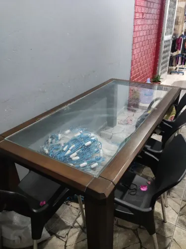 Mesa de madeira maciça com tampo de vidro.