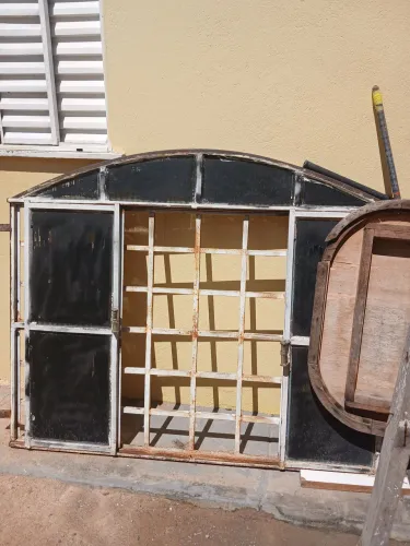 Vendo uma portador madeira acompanha o portal e uma janela com o vidro 