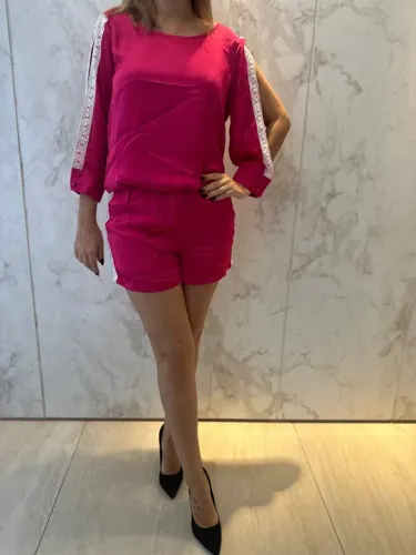 Macacão rosa com detalhes em renda.