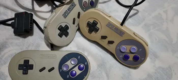 Três controles originais de Super Nintendo
