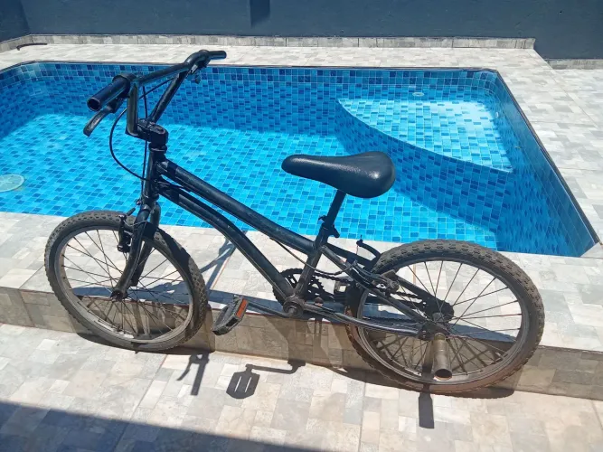 Bicicleta preta com pneu seminovos com pedaleira dourada mais uma Câmara de ar no saco 