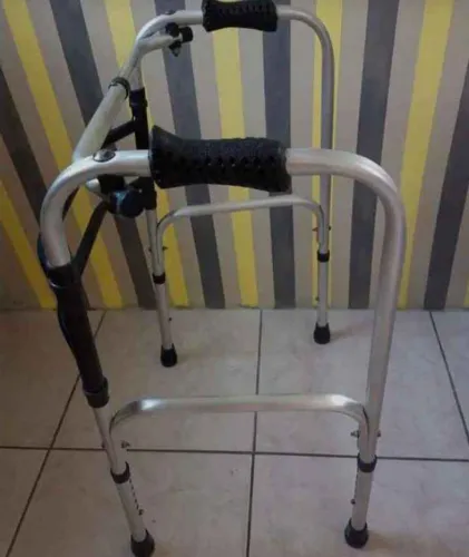 Andador articulado em alumínio resistente, com regulagem de altura e ponteiras .