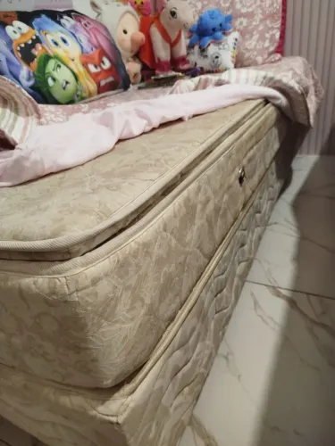 Cama de solteiro com base e colchão da Ortobom. Cabeceira, travesseiro e lençóis bordados.