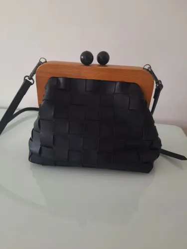 Bolsa preta estruturada com detalhe em madeira