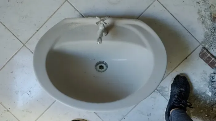 Pia cinza com coluna e torneira