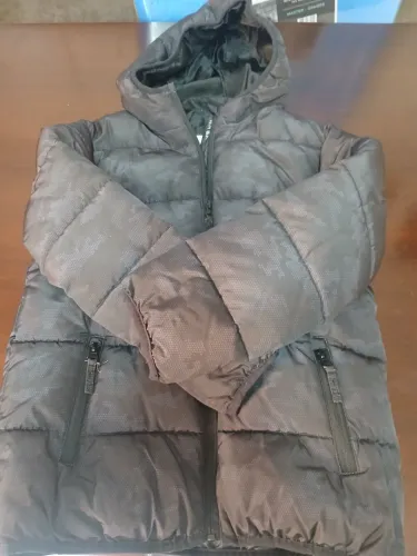 jaqueta infantil puffer preta com capuz e estampa camuflada discreta, em perfeito estado