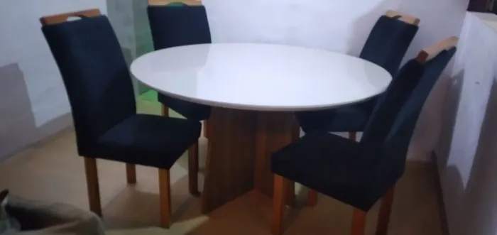 Mesa redonda tampão de vidro, com 6 cadeiras tecidos azuis.