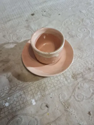 Xícara de cerâmica rosa artesanal com pires