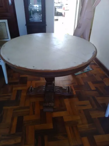 Mesa de jantar redonda com pés entalhados