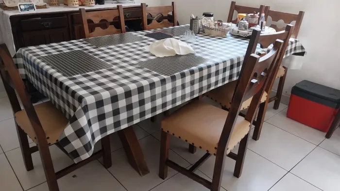 Mesa para 8 lugares com cadeiras de madeira e acabamento em couro e de madeira maciça .