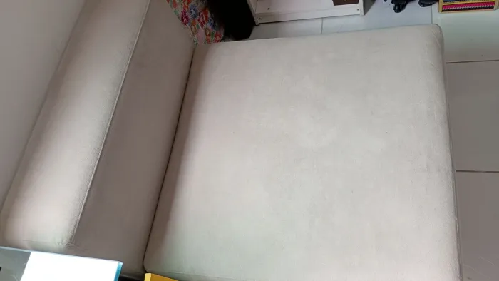 Poltrona com revestimento em suede, medindo 1,10cm de comprimento por 0,85cm de largura.
