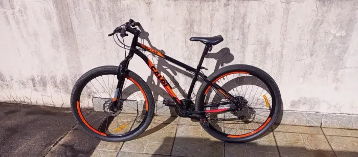 Caloi Vulcan aro 29, preta e laranja, com freios a disco.