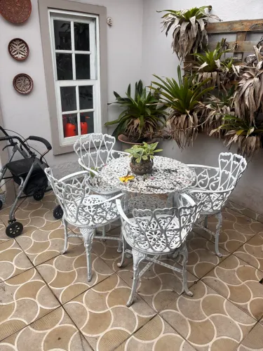 Mesa de ferro com 4 cadeiras de jardim.