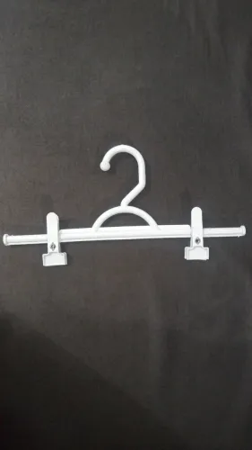 Cabides de plástico na cor branco com prendedores 