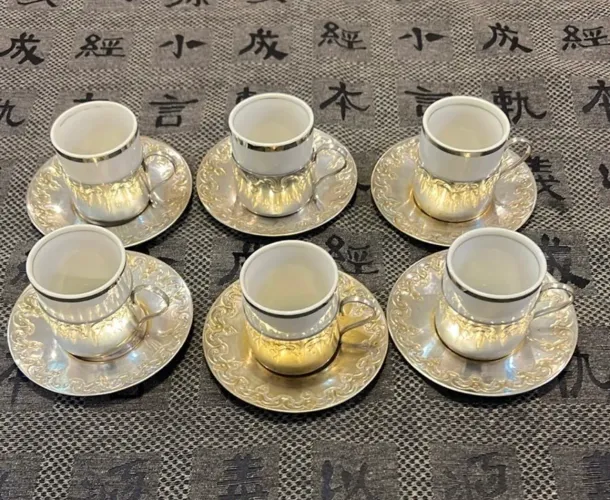 Conjunto para café com xícaras em porcelana e porta xícaras e pires em metal