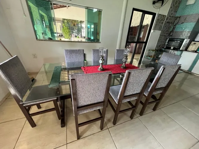 Mesa de vidro com base em madeira de lei, mais 8 cadeiras.