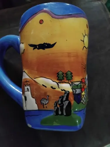 Caneca em porcelana,  importada, com decoração em alto relevo e motivos do Chile. 