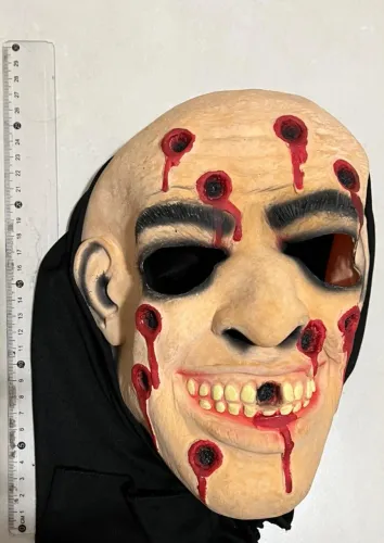 Máscara de homem careca com marcas de tiro e sangue