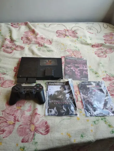 Vendo um Playstation 2 com um controle com três CD de jogos de tiro e dois jogos de luta .