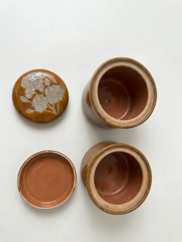 Dois potes de cerâmica vitrificada marrom com desenhos de flores