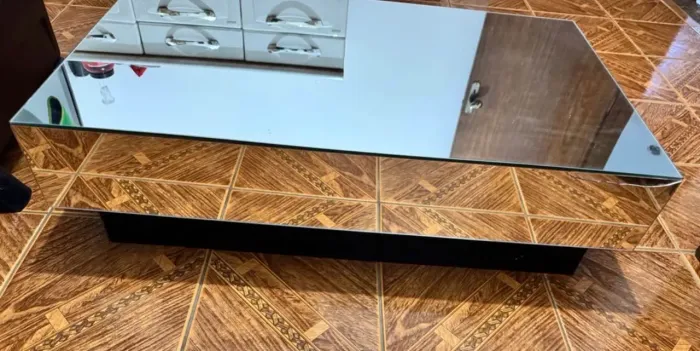 Mesa de centro espelhada com um pequeno trincado na lateral