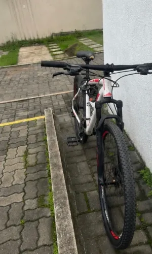 bike Oggi Hacker Sport aro 29, na cor branca com detalhes em vermelho.