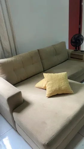 Sofá com chaise na cor bege.