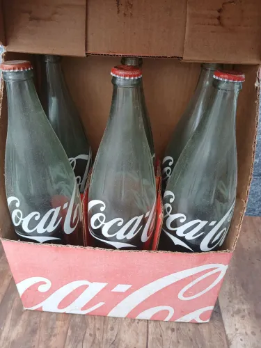 Caixa com 6 garrafas vazias retro de Coca Cola.