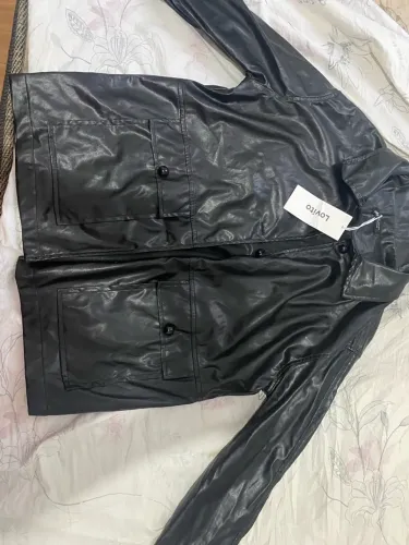 Jaqueta preta de coro sintético e vestido preto brilhoso
