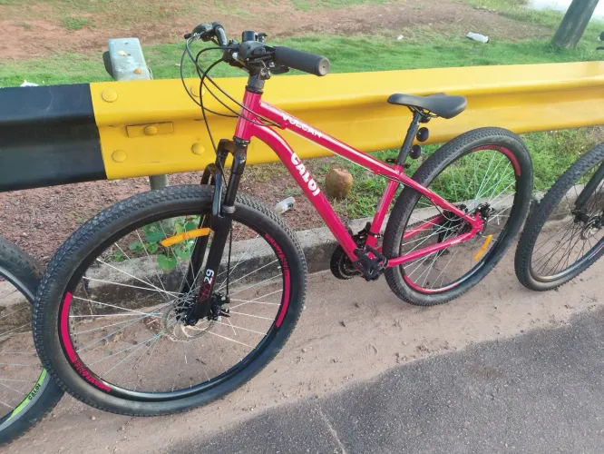 Bicicleta aro 29 com alguns acessórios como lanterna e sinalizador.