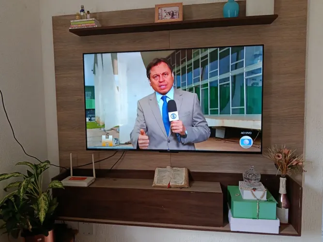 Painel de tv com duas prateleiras e uma gaveta dobrável.