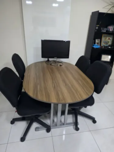 Mesa de reunião com 4 cadeiras acolchoadas.