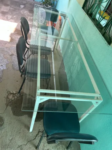 Mesa de vidro com pés de metal.