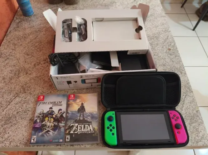 Nintendo Switch completo na caixa com jogos Zelda Breath of de Wild e Fire Emblem Warriors