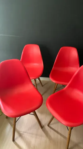 Conjunto 4 Cadeiras Eames DSW vermelha com pés de madeira.