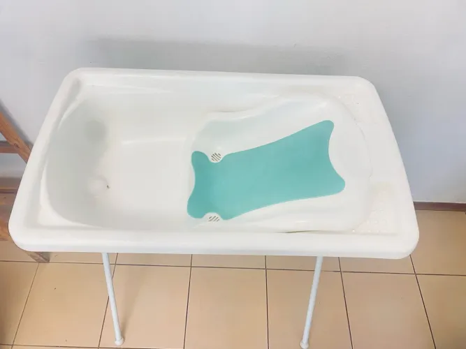 banheira Burigotto branca com suporte dobrável e assento redutor verde