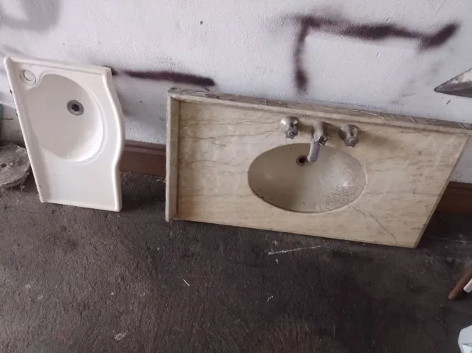 Duas pia de banheiro sendo uma de mármore.