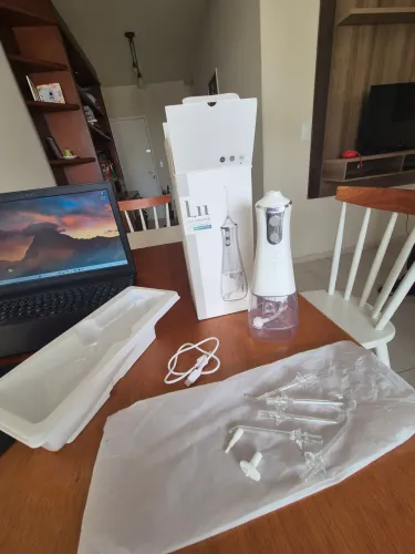 Irrigador oral portátil recarregável branco com tanque de água.