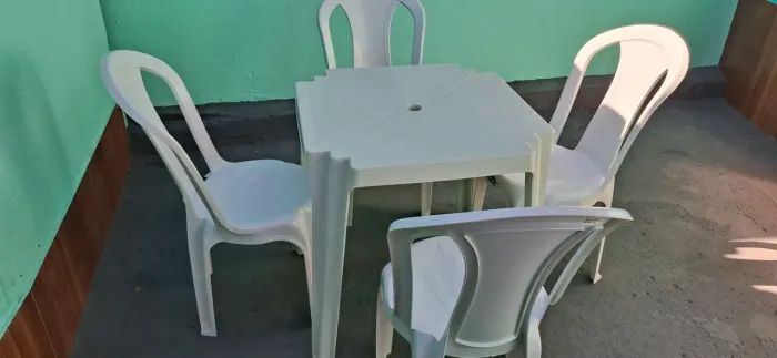 Mesa com 4 cadeiras da Plástico na cor branca semi nova disponível para outra família usar