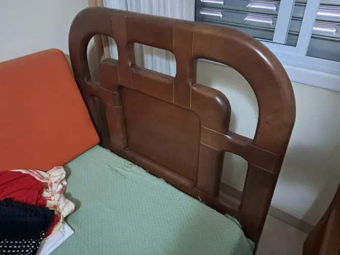 Cama de solteiro em madeira maciça com colchão.