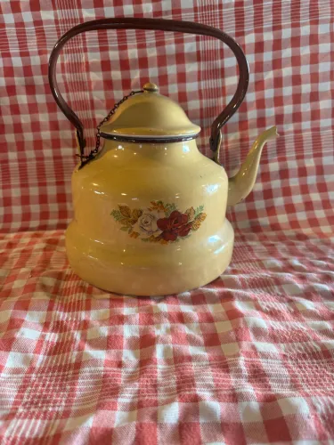 chaleira esmaltada vintage em tom amarelo com uma estampa floral de rosas.