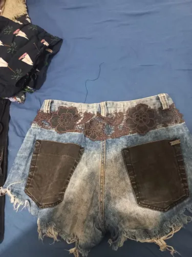 Short jeans destroyed Espaço Fashion, com detalhe marrom na barra.