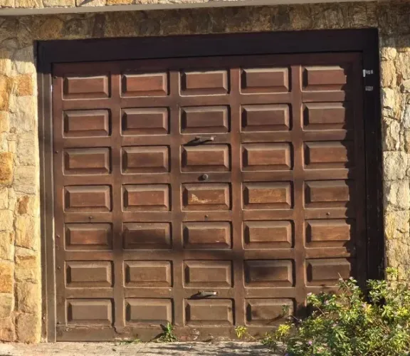 Portão pequeno de madeira para garagem com estrutura reforçada em ferro