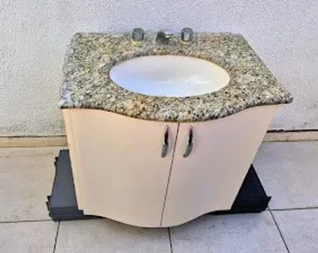 Gabinete de banheiro com pia de mármore e torneira.