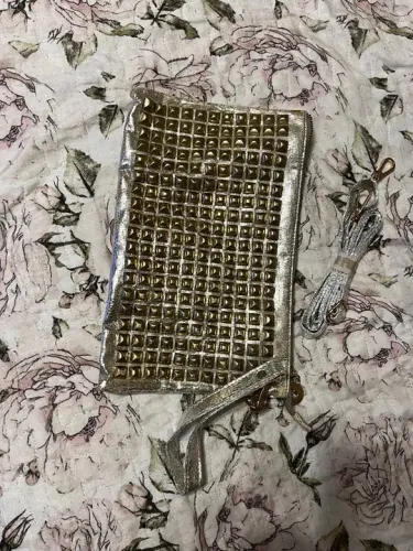 Bolsa de mão dourada com tachas