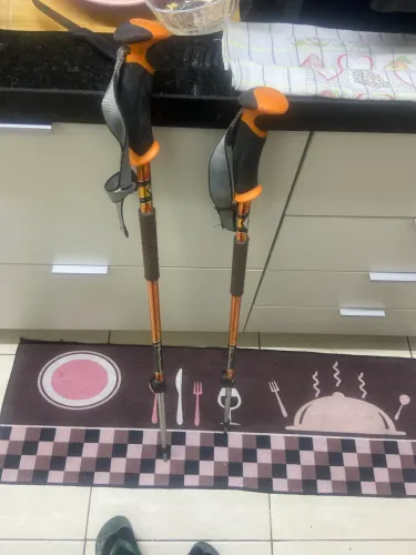 bastões de trekking parecem ser o modelo Naturehike Trail Lite na cor dourada/laranja.