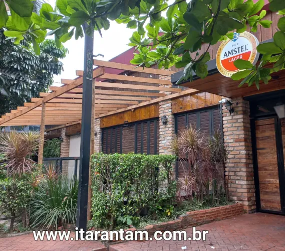 Pergolado de madeira com cobertura de policarbonato e forro de bambu. 